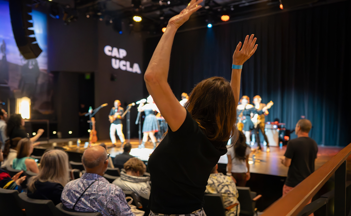 An audience member at The Nimoy dances while a performance occurs on stage