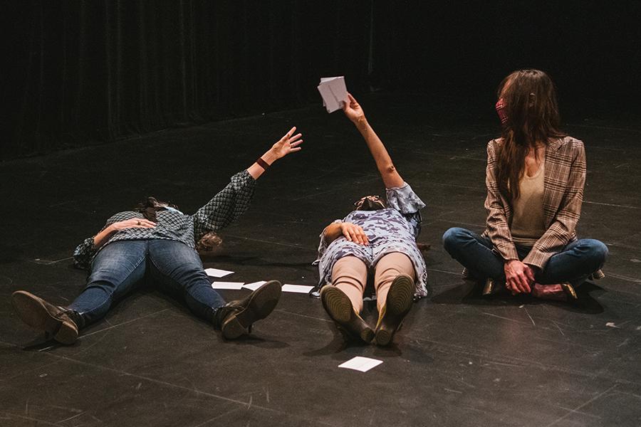 Two participants of 600 Highwaymen lay on the floor while a third sits and watches on