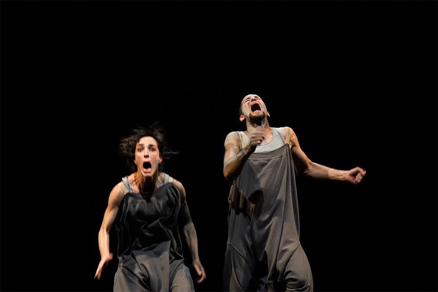 Dancers perform on stage in front of black backdrop