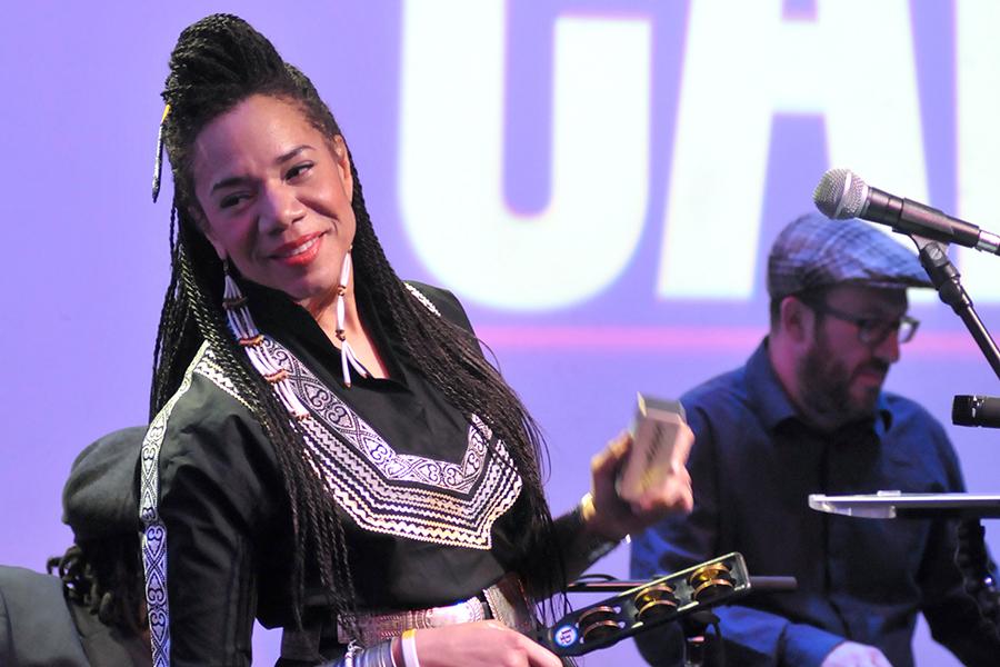 Martha Redbone smiling and performing onstage with her band