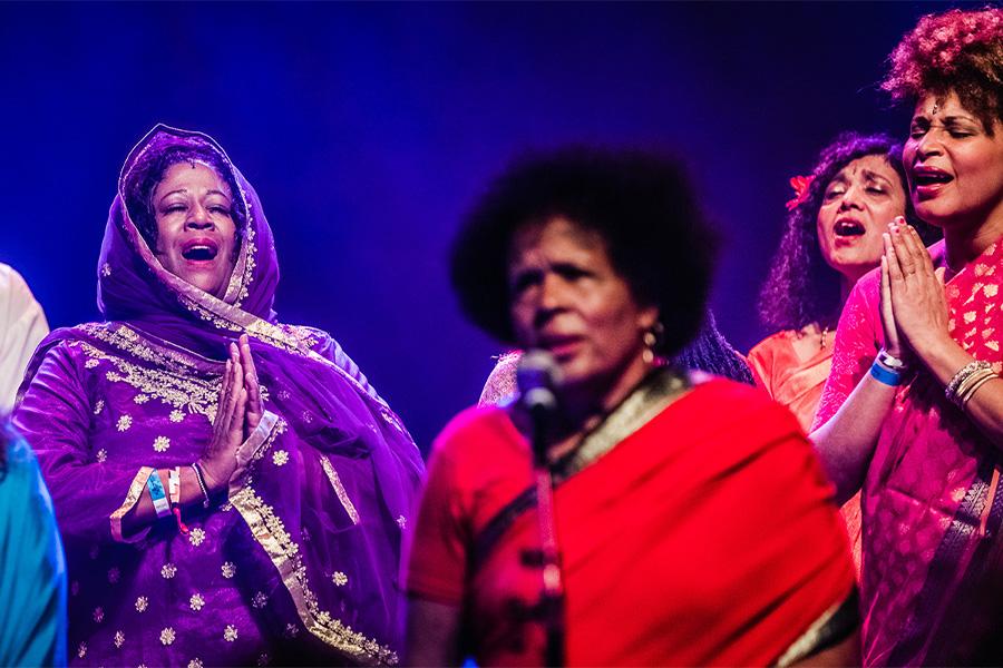 Performers from Sai Ananam Devotional Ensemble perform on stage